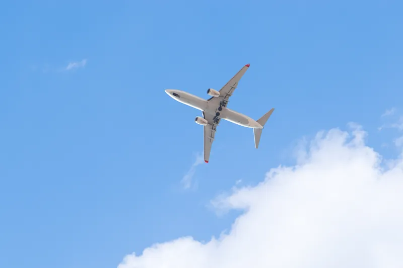 Flugzeug am blauen Himmel über weißen Wolken